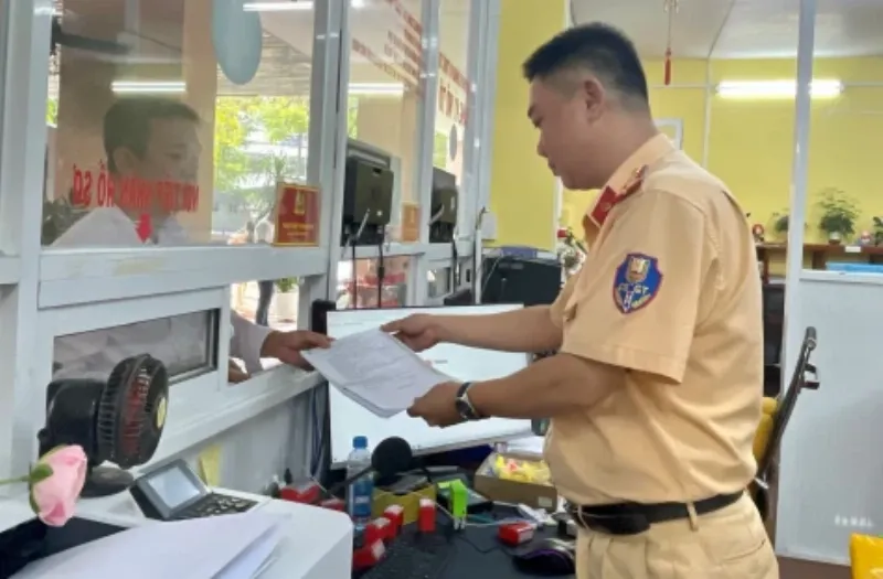 Người dân nộp hồ sơ làm lại đăng ký xe máy tại quầy tiếp nhận hồ sơ đăng ký xe